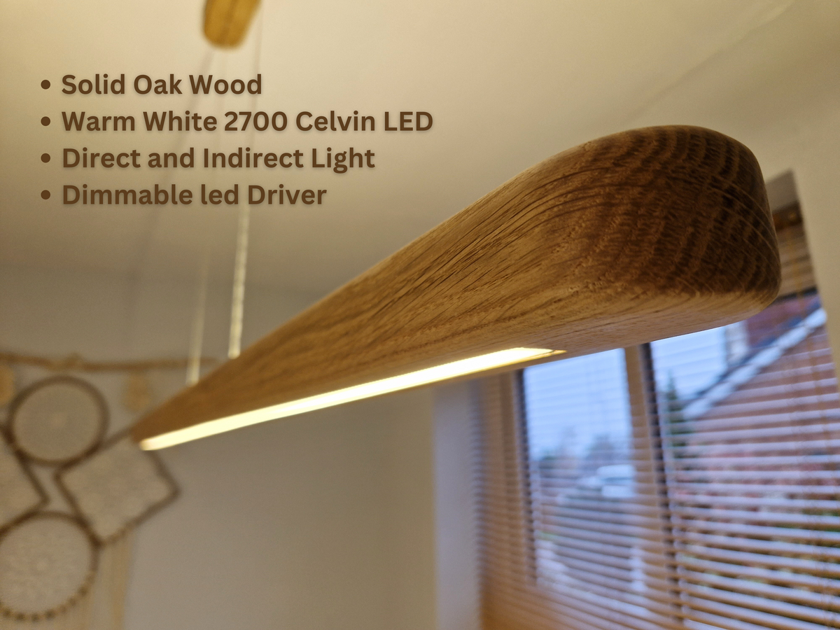 A curved solid oak wood pendant light fixture with warm white LED lighting, shown hanging in a home interior with text overlays detailing its features.