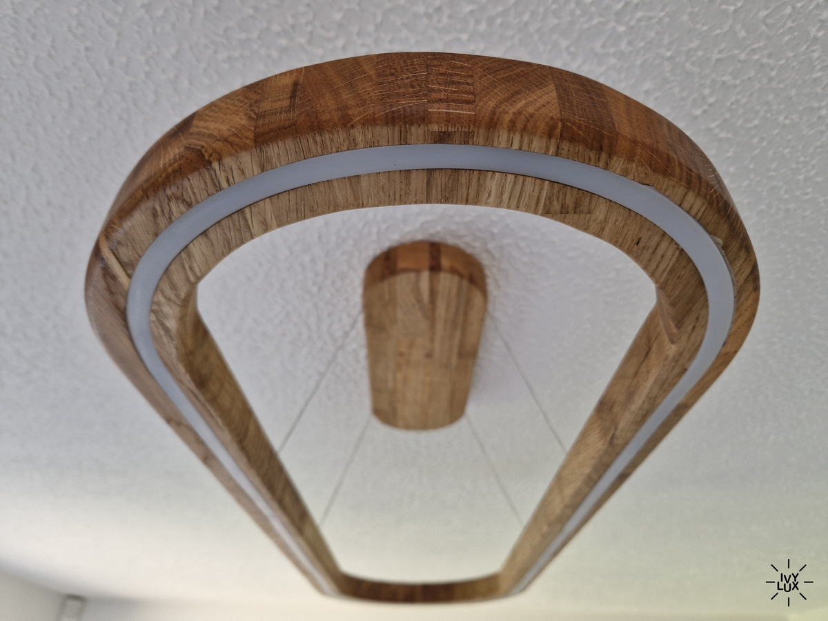 A modern geometric ceiling light fixture with a natural wood frame and a white LED light strip, shown installed on a textured white ceiling.