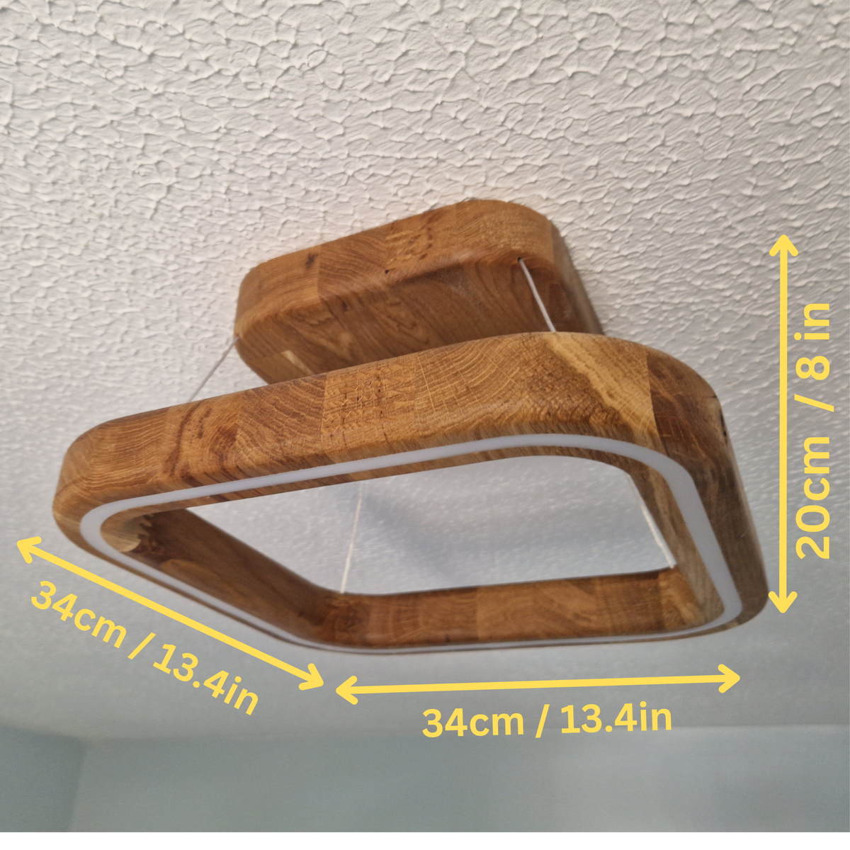 A modern square ceiling light fixture made of natural wood, shown with yellow dimension arrows and text indicating measurements of 34cm by 20cm.