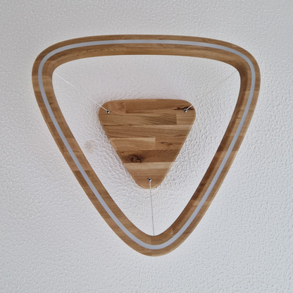 A triangular wooden LED pendant light viewed from directly below, showing an open triangle ring frame around a smaller triangular wooden ceiling mount, installed on a textured white ceiling.
