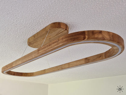 A modern linear LED ceiling light with a curved wooden frame, suspended from a matching wooden ceiling mount against a textured white ceiling.