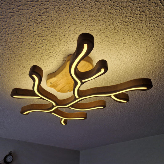 An organic-shaped ceiling light fixture with a dark wood frame and warm yellow LED tubing, mounted on a textured white ceiling.