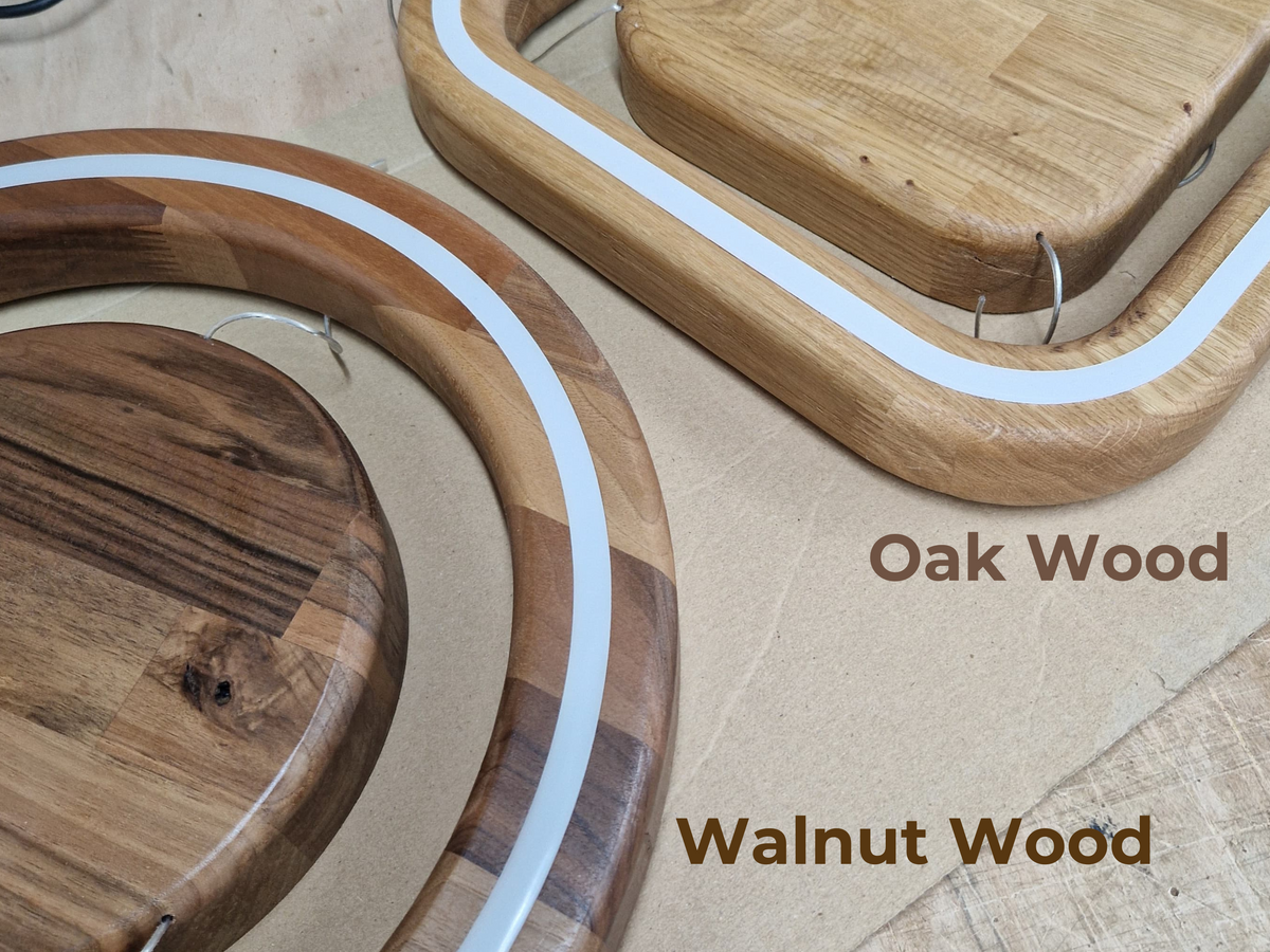 Two wood ceiling light fixture frames with an embedded white LED diffuser channel, comparing the Oak Wood (round) and Walnut Wood (square) finish options side by side.